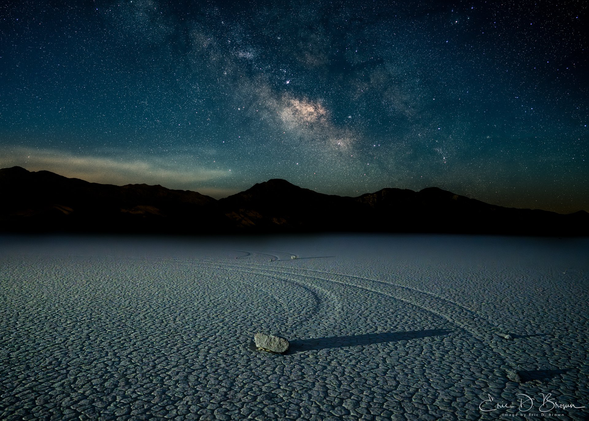 The Moving Rocks -  Milky Way photograph over the famous sailing stones at Racetrack Playa in Death Valley National Park. The mysterious moving rocks leave trails across the dried lake bed beneath the galactic core.