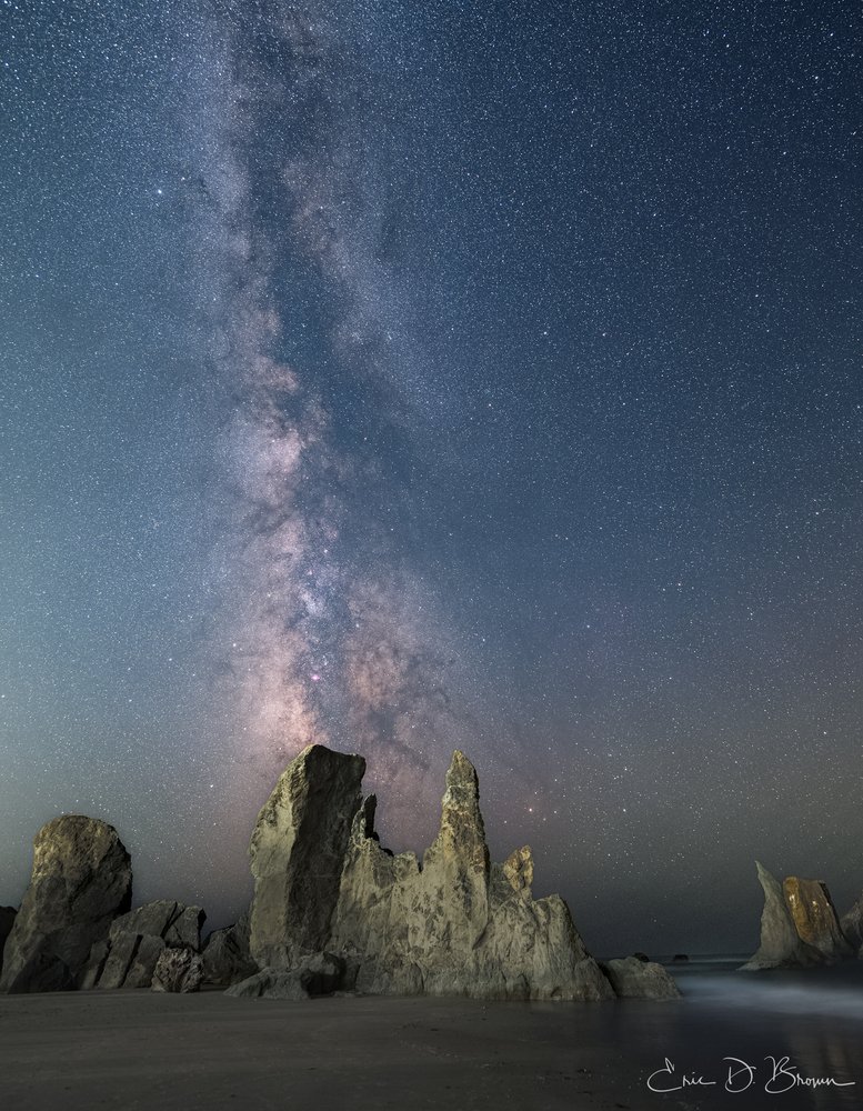 Capturing the Milky Way at Bandon Beach - The night sky reveals its splendor over Bandon Beach's iconic rock formations, with the Milky Way's celestial river perfectly aligned above these natural monuments during a rare clear evening on the Oregon coast.