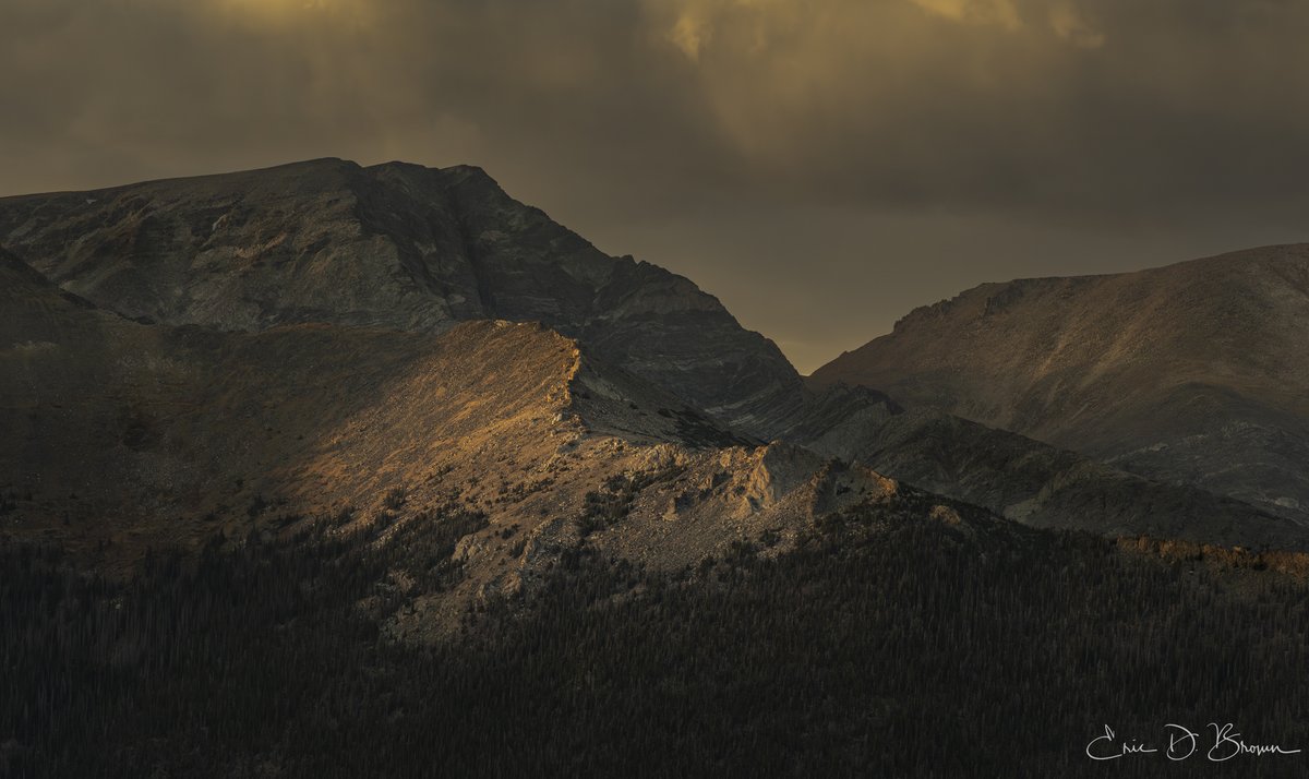 Last Light on the Ridge - The fading sun casts a spotlight on nature's grandeur, illuminating a rugged ridge against the gathering dusk of Rocky Mountain National Park.