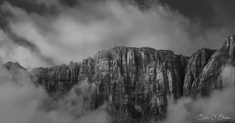 Veiled Monoliths: When Clouds Embrace the Cliffs - by Images by Eric D. Brown