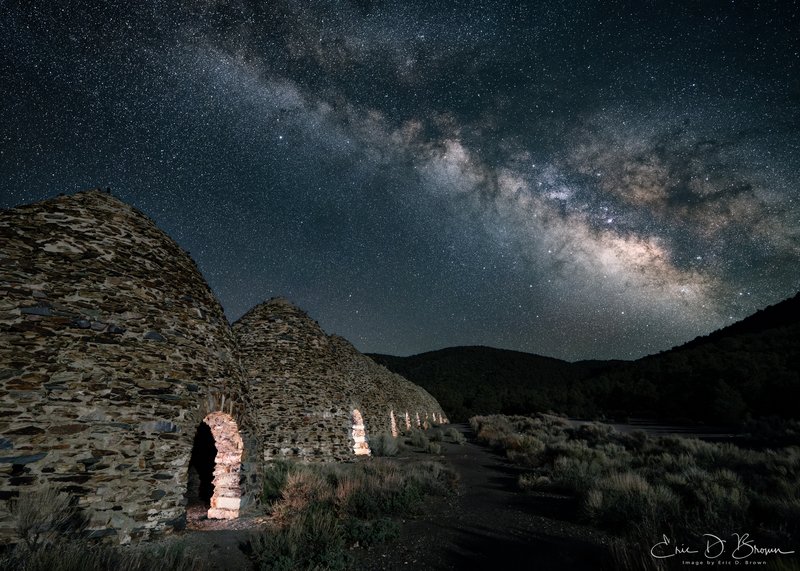 Death Valley Charco Kilns -  In the dark wilderness of Death Valley, where the bustle of modern life fades into silence, the historic Charco Kilns stand as silent sentinels of a bygone era. This photograph captures these remarkable stone structures beneath the cosmic river of the Milky Way, creating a striking juxtaposition between human history and celestial timelessness.